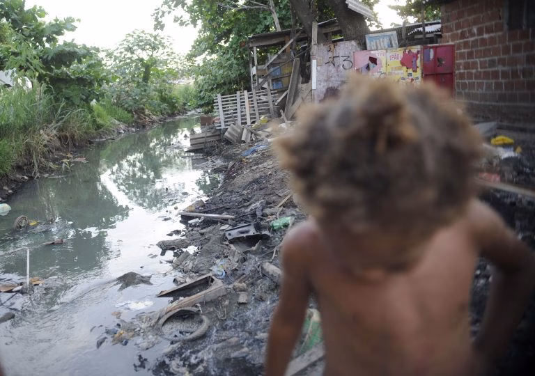 Eleições 2026: especialistas analisam desafios em habitação, saneamento e esporte 2 Cidades - favelas e pobreza - infraestrutura esgotos saneamento básico periferias infância crianças (moradores do Complexo da Maré, no Rio, sofrem com a falta de saneamento, 2014)